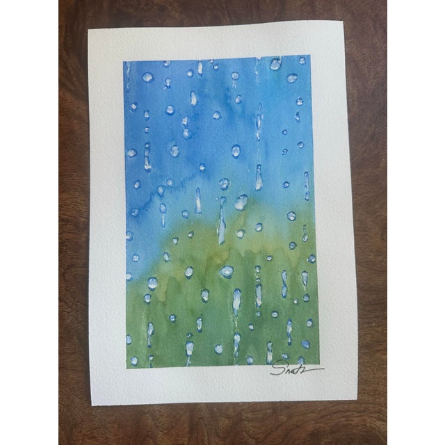 A fresh and uplifting watercolor capturing the simple beauty of raindrops on glass. Soft washes of sky blue and spring...