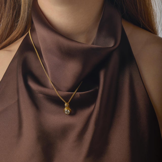 This refined vintage diamond necklace is a beautiful blend of antique charm and timeless elegance, centered around two...