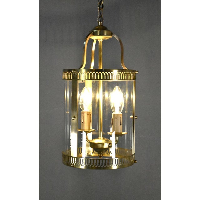 An attractive round hall lantern featuring pierced brass continuous rings at the top and bottom that hold three curved...