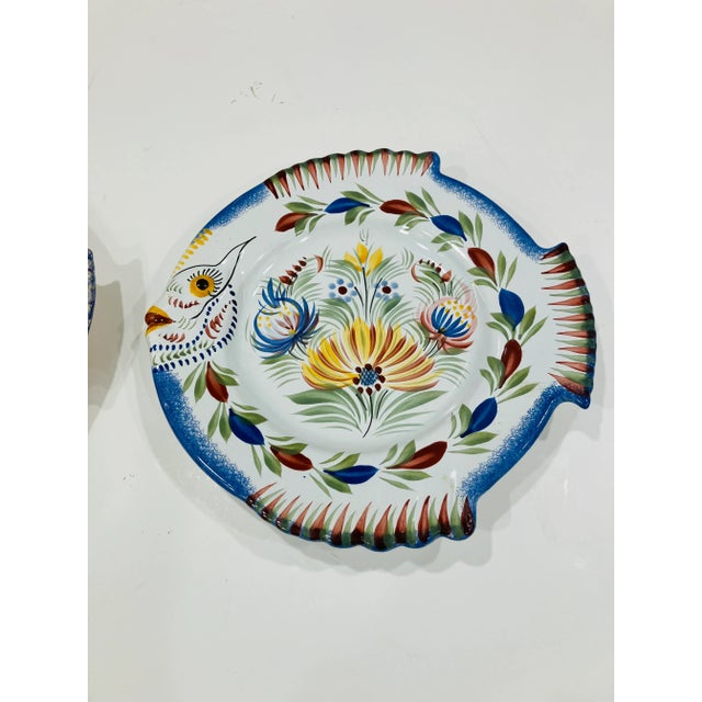 This pair of hand painted plates is signed Henriot Quimper The quality of painting is finely detailed The condition is...