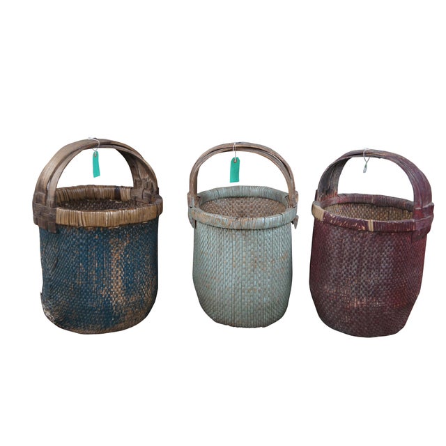 Set of three antique Chinese rice basket featuring woven reed and willow with bentwood handle. Each basket has been...