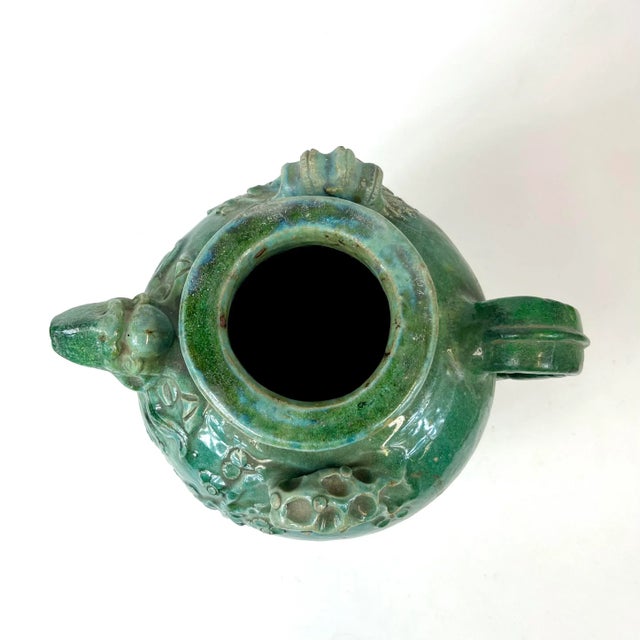 This robust jug has handles on either side but each decorated differently with blossoms adorning one handle and bamboo...