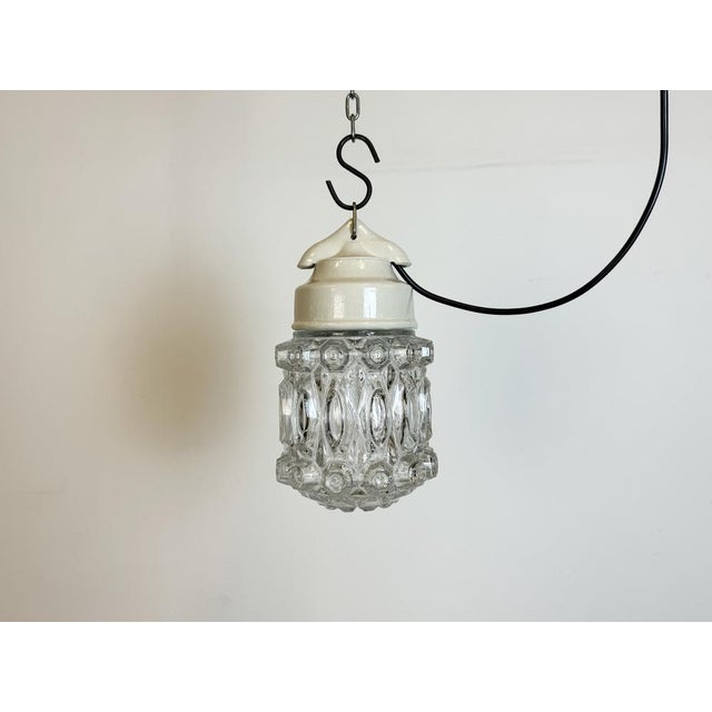 Vintage industrial light made in former Czechoslovakia during the 1970s. It features a white porcelain top and a glass...