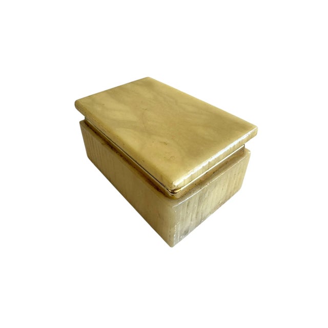 A refined mid century alabaster box, expertly carved from solid stone with natural veining in soft, muted tones. The...