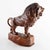 Finely carved wooden sculpture depicting a standing lion poised atop a naturalistic rocky outcrop. Executed with...