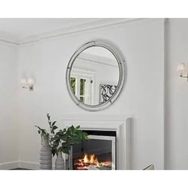 Finely crafted wall mirror with a polished stainless steel frame. Hardware is hand-cast from stainless steel with a...
