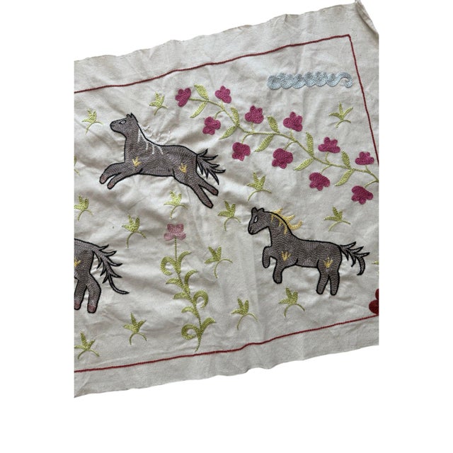 Hand-embroidered Suzani panel from Uzbekistan, worked in fine floss on a cream cotton ground. Seven grey horses move...