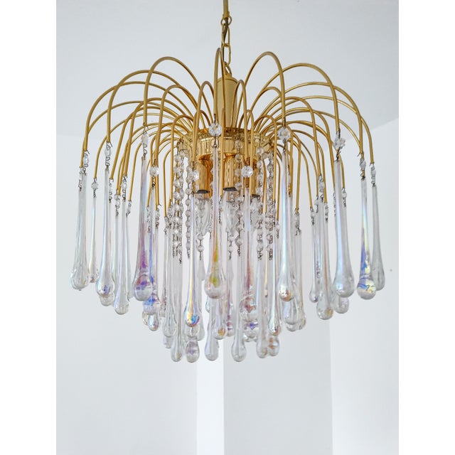 Elegant 1970s Murano glass chandelier attributed to Paolo Venini, featuring a gilded metal frame with cascading clear...