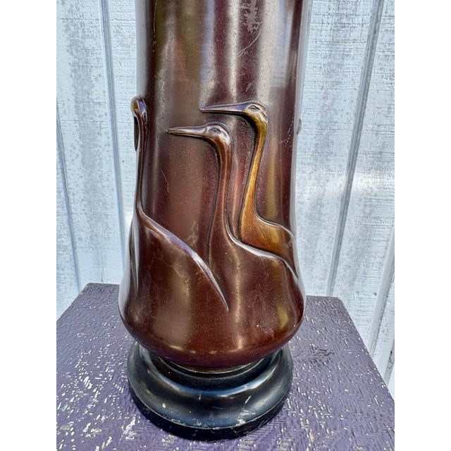 Elegant and rare, this antique Chinese bronze lamp features a beautifully detailed flock of cranes or herons in graceful...