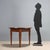Directoire walnut console table. Demi-lune top, supported by three truncated pyramidal legs, joined by a band under the...