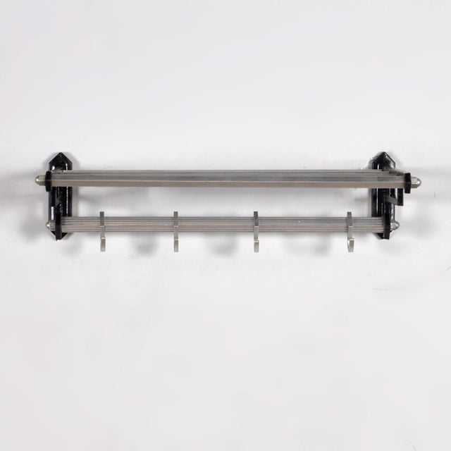 Wall coat rack in art deco style from the 1950s, made of iron and aluminium and equipped with 4 sliding hooks on a square...