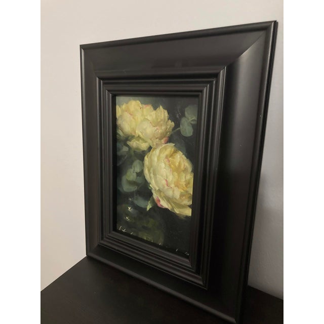 This oil painting depicts a pair of yellow peonies, their lush petals rendered with soft, fluid brushstrokes that evoke a...