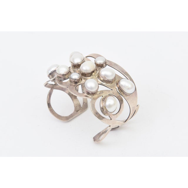 This stunning artisan made wide cuff bracelet is sterling silver and real pearls. It is most likely one of a kind. It is a...