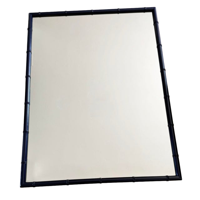 A classic faux bamboo mirror in a rich navy blue finish. The frame features the signature bamboo joint detailing at the...