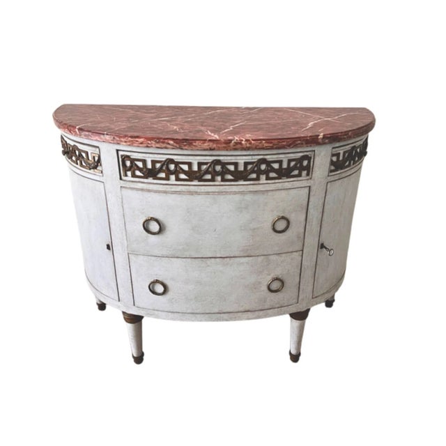 A charming 19th-century Swedish Gustavian demilune commode distinguished by its elegant proportions, richly veined rouge...