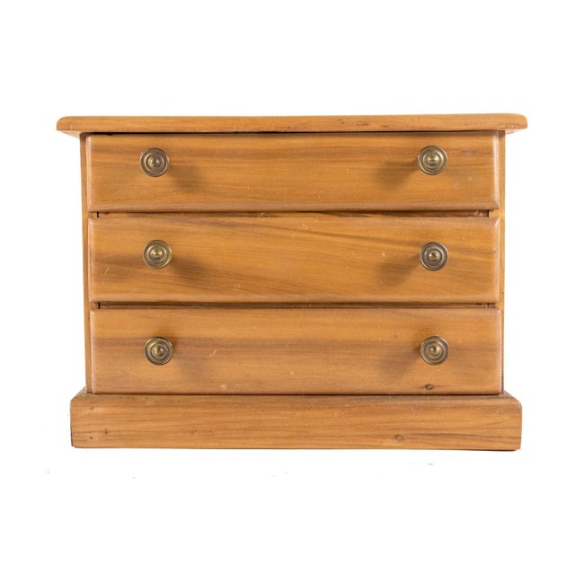 A small vintage salesman sample chest of drawers with three felt-lined long drawers and brass pulls. No maker’s mark....