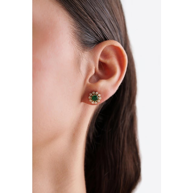 These floral cluster stud earring feature 1.08 carats of emerald & diamonds, set in 14K yellow gold. Each emerald...