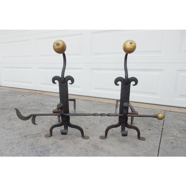 Substantial American Arts and Crafts era artisan blacksmith-made andirons with a matching tool set all formed of wrought...