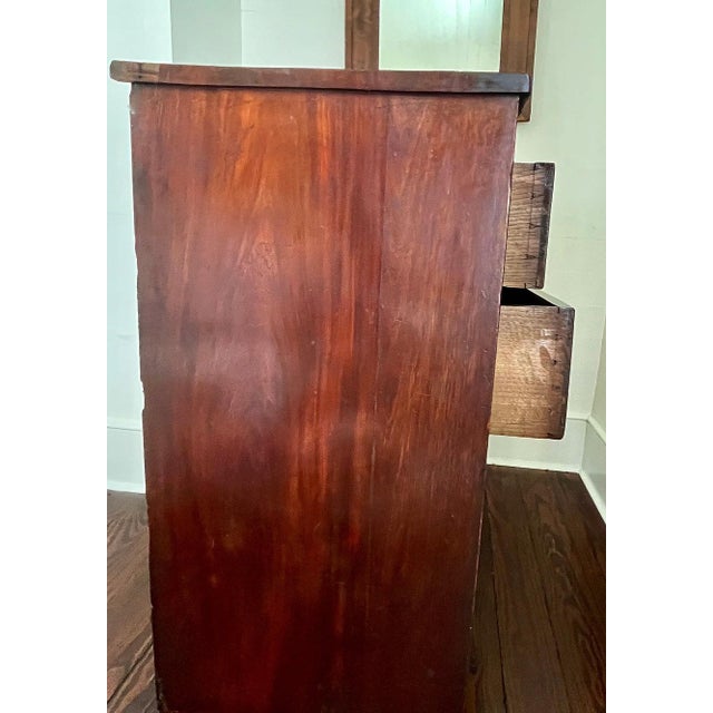 This antique chest of drawers bears a lovely patina and plenty of storage capacity. Each drawer feaures brass escutcheons...