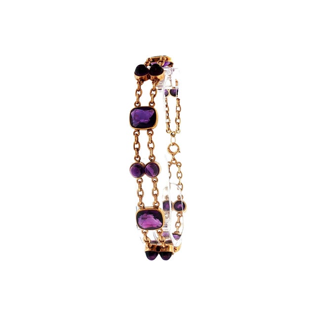 A mid-20th-century link bracelet crafted in 14k gold. Features 4 cushion-cut amethyst stones, totaling 8.0 carats, in a...