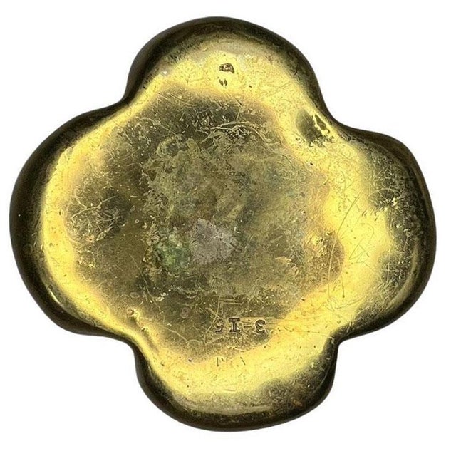 A solid brass clover shape paperweight, ashtray, or trinket dish with a dog head at the center. This shiny gold dish will...