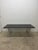 Smoked glass top dining table top on a rectangular chrome base with tubular chrome legs originally designed by Tobia...