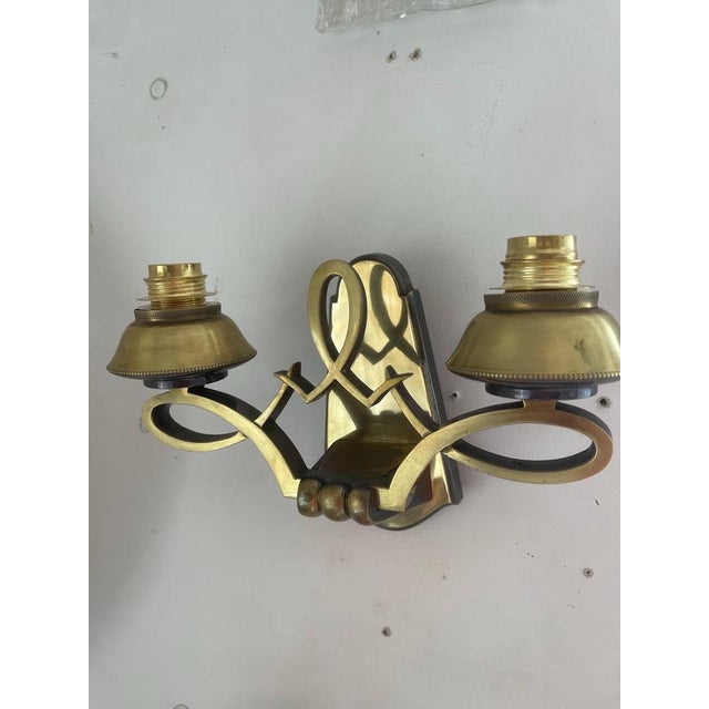 A distinguished pair of two-light wall sconces by the celebrated Parisian lighting house Maison Liberos, each bearing the...