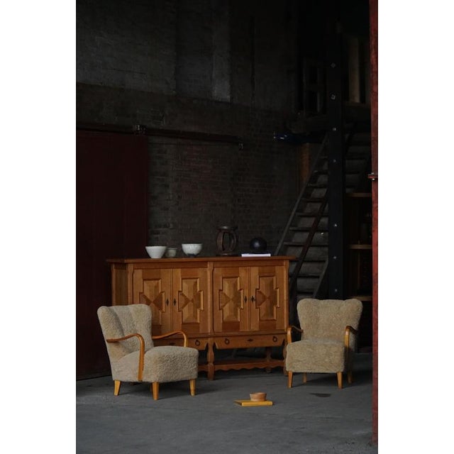 A timeless pair of Swedish modern lounge chairs in birch and reupholstered in high quality shearling lambswool which adds...