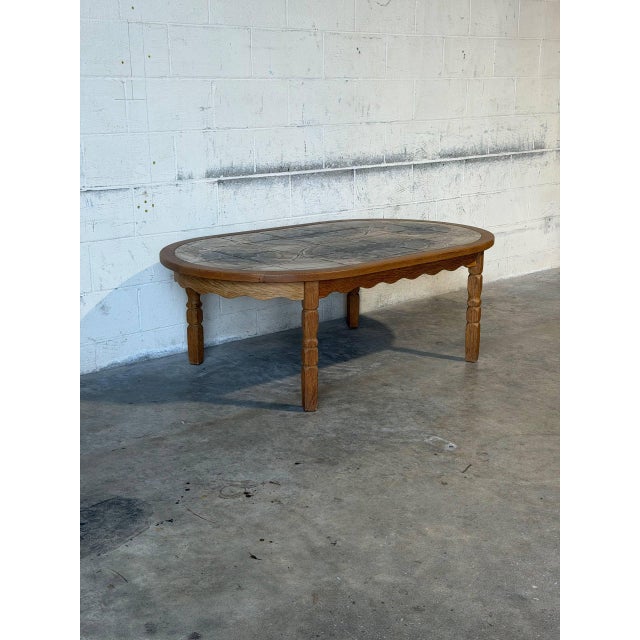 This oval coffee table features a beautifully patterned inset tile top. The frame is distinguished by a decorative...
