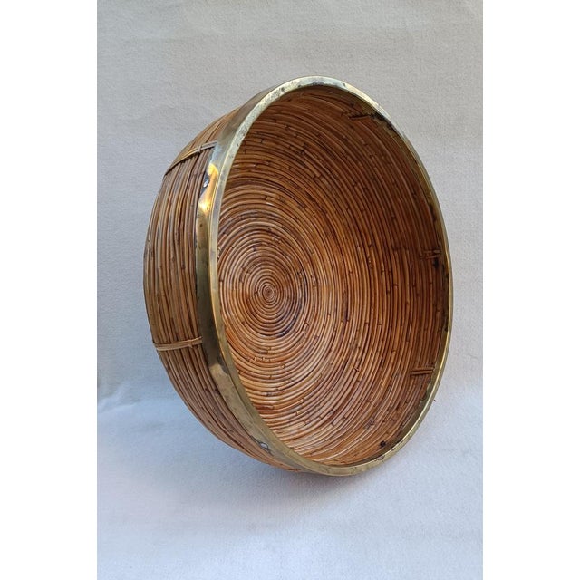 Large wicker basket with a brass-nailed edge. Italian manufacture from the 1970s in the style of Gabriella Crespi....