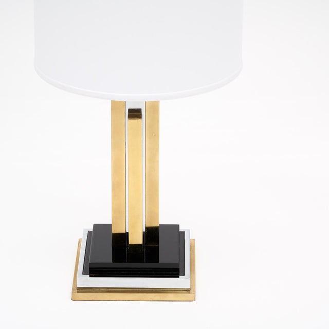 Table lamp from France in the style of Philippe Cheverny. This modernist piece mimics a stylized skyscraper with brass and...