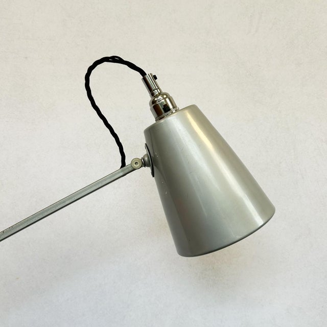 Painted metal conical shade on a steel articulated arm with parallel rod construction and counterweight mechanism. Chrome-...