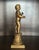 An antique decorative figure depicting a young boy standing atop a fluted classical pedestal. Cast in spelter and finished...