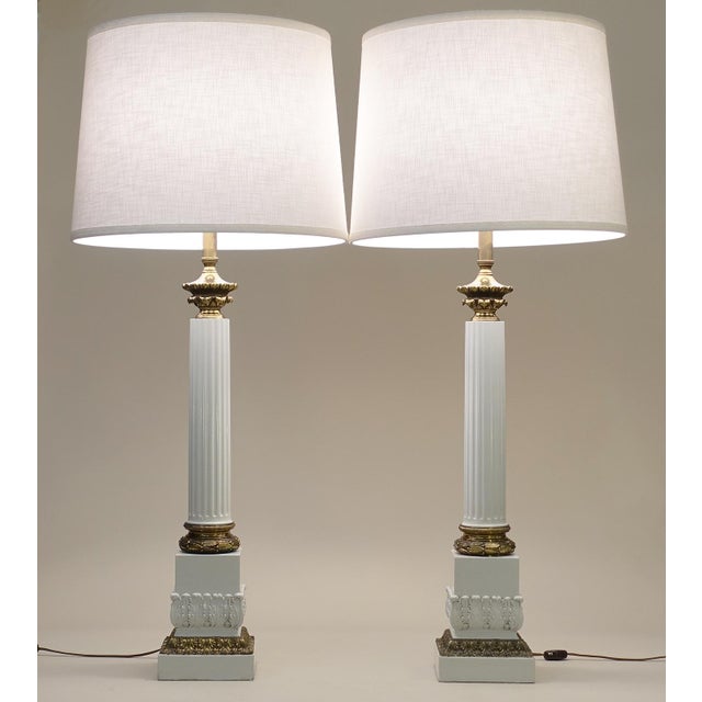 A bold and impressive matched pair of vintage Neoclassical Modern Brass Composite-stylized Column table lamps designed by...