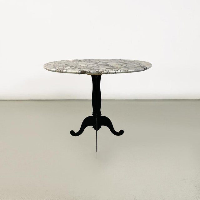 Italian and modern period coffee table with oval marble top and black-painted molded metal legs, ca. 1970. Coffee table...