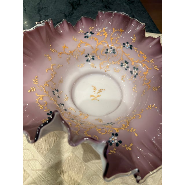 Victorian-era hand-blown art glass bride's bowl with a mauve or pink cased glass ruffled rim and hand-painted gold scrolls...