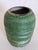 A Colorful Green Raku Cetamic Vase featuring a swirling etched grid pattern, hand signed on the bottom.