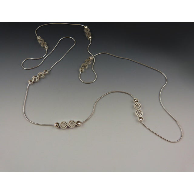 The artist hand-fabricated sterling silver "dazzelers" and connected them to segments of sterling-silver snake chain, to...