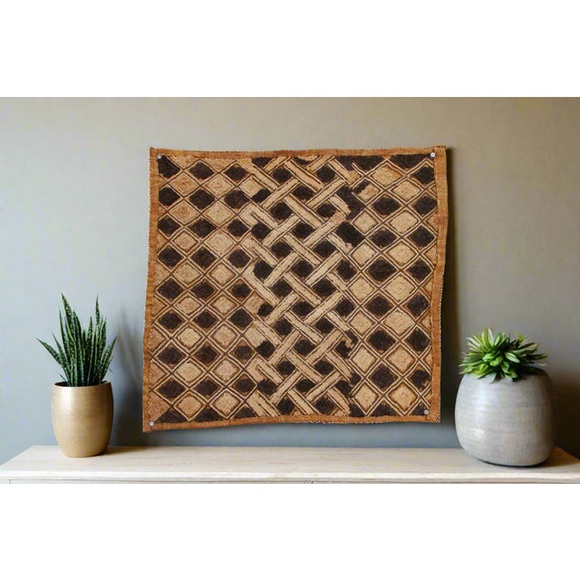 A captivating masterpiece of African textile art, this vintage Kuba cloth panel is a testament to the unparalleled...