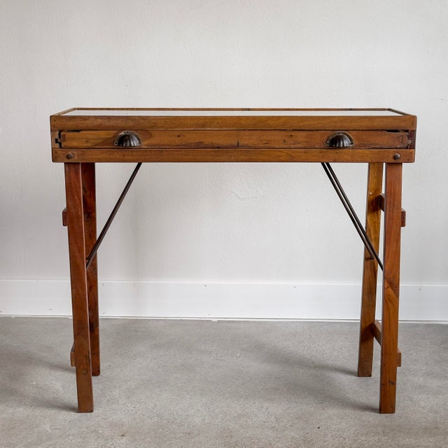 Fully collapsable glass-top console table featuring a pull-out vintage letterpress tray. Perfect for displaying...