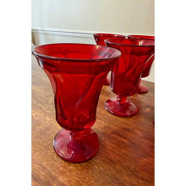 Six vintage Fostoria Jamestown Ruby Red Ice Tea Goblets, distinguished by their vibrant deep red color and elegant pressed...