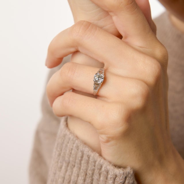 A refined treasure from the 1920s, this authentic Art Deco engagement ring showcases a luminous 0.89 carat old European...