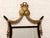 A dramatic vintage wall mirror with an elegant Hollywood Regency feel, featuring a black frame richly accented with gilt...