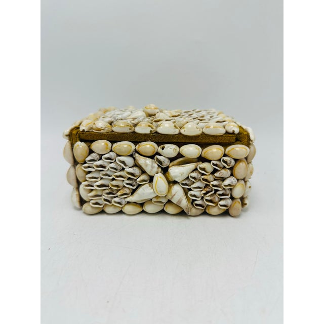 A small vintage handmade shell trinket box, constructed on a wooden base and completely covered in tiny natural seashells....