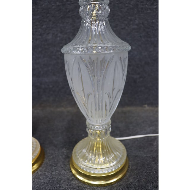 Pair of cut to clear crystal table lamps with etched detail throughout the bodies. Each lamp features a tapered form with...
