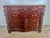 19th century English feathered mahogany chest of drawers. There are finely carved panels flanking the chest that depict...