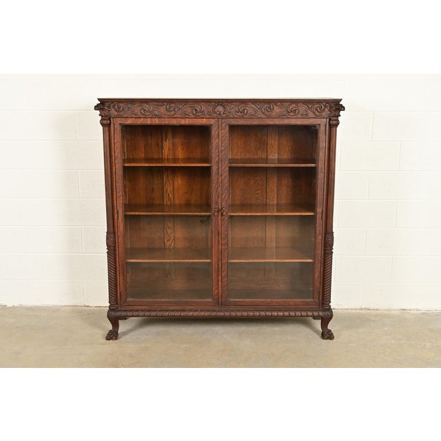 An outstanding antique American Empire or Victorian double bookcase cabinet with lion heads and paw feet In the manner of...