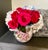 A richly detailed, hand‑painted porcelain vase featuring a lush wraparound floral motif in shades of pink, white, and...