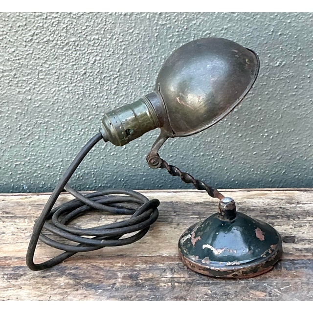 This antique industrial task lamp is a quintessential example of early 20th-century Machine Age design. Featuring a rugged...