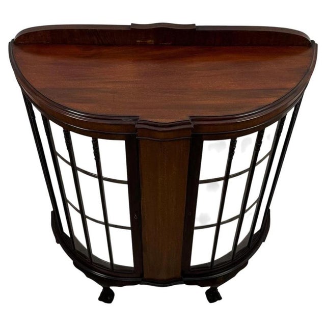 An elegant early 20th-century English display cabinet, finely crafted from mahogany and distinguished by its graceful bow-...